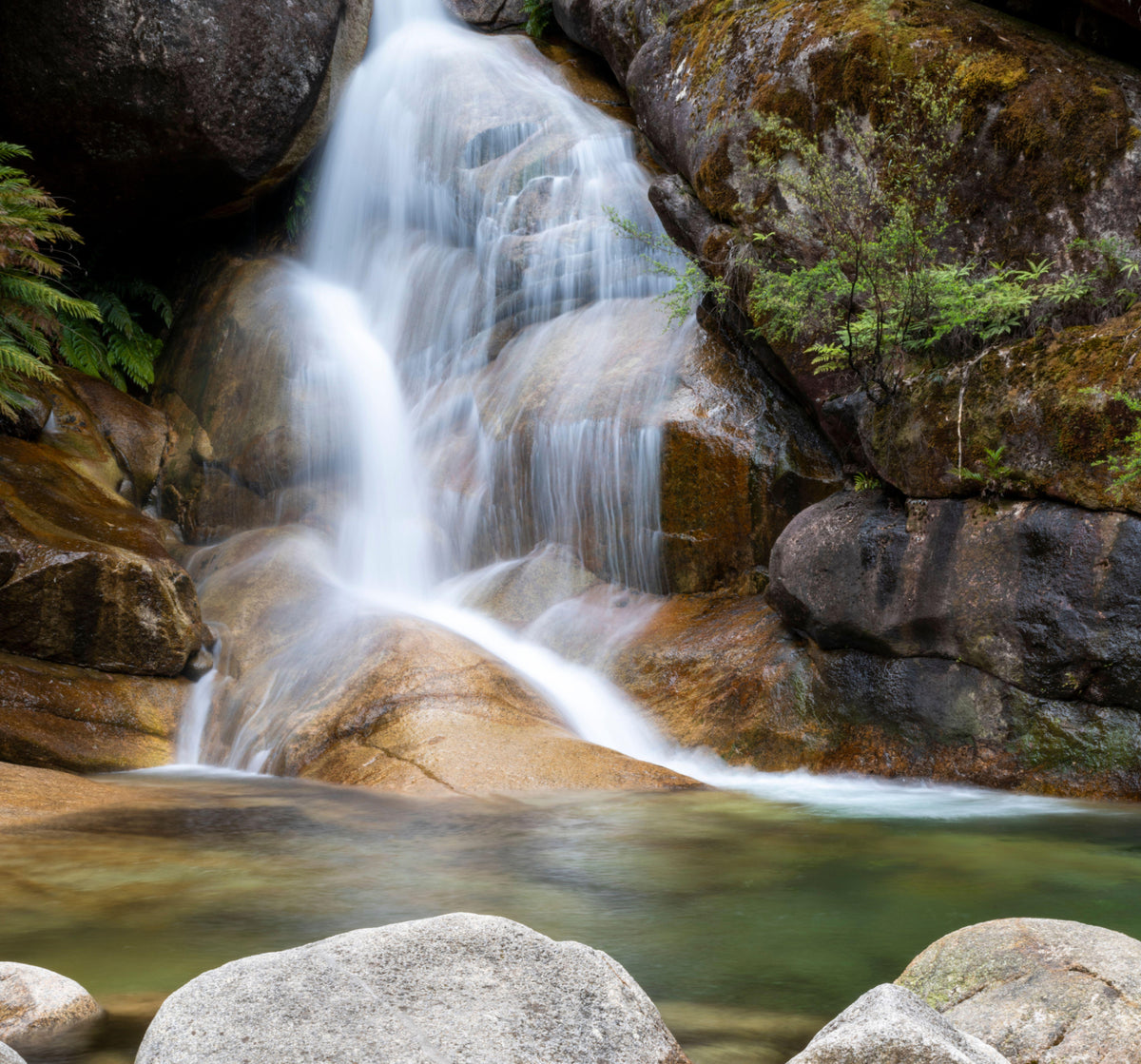 A waterfall tumbling over granite into a clear rock pool in the high country above Beechworth