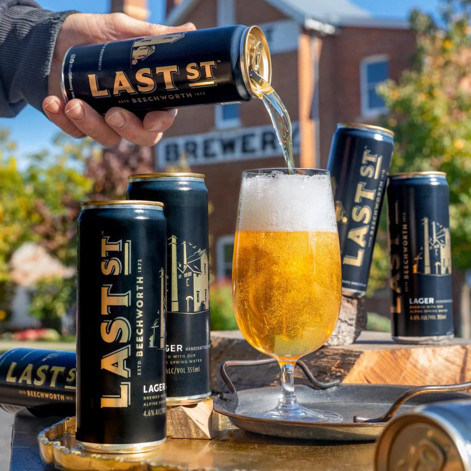 Last St Lager poured from the can beside a stack of cans